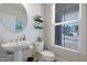 Charming powder room with pedestal sink, large mirror, and a window bringing in natural light at 624 Red Arrow Dr, Knightdale, NC 27545