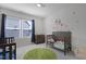 Cozy bedroom with a crib, dresser, green rug and natural light from two windows at 624 Red Arrow Dr, Knightdale, NC 27545