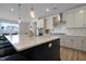 Modern kitchen with stainless steel appliances, a quartz countertop, a large island with seating, and light fixtures at 624 Red Arrow Dr, Knightdale, NC 27545