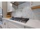 Gourmet kitchen boasts a stainless steel gas cooktop, stylish backsplash, and quartz countertops at 624 Red Arrow Dr, Knightdale, NC 27545
