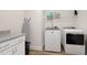 Well-equipped laundry room with modern appliances, folding table and built in shelving at 624 Red Arrow Dr, Knightdale, NC 27545