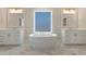 Spa-like bathroom with freestanding tub, and vanity, marble floors, and window at 624 Red Arrow Dr, Knightdale, NC 27545