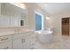 Luxurious bathroom with double sink vanity, soaking tub, and marble tile flooring at 624 Red Arrow Dr, Knightdale, NC 27545