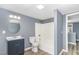A gray bathroom features wood-look flooring, blue vanity, and shower-tub combo at 636 Tucker St, Burlington, NC 27215