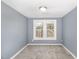 A gray carpeted bedroom is freshly painted with two white-trimmed double windows at 636 Tucker St, Burlington, NC 27215