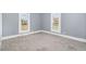 Bright bedroom with two windows, neutral walls, and carpet flooring at 636 Tucker St, Burlington, NC 27215