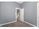 A carpeted gray room with white trim includes the stairway in the background at 636 Tucker St, Burlington, NC 27215