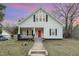 Charming two-story home featuring a welcoming front porch and a freshly painted red front door at 636 Tucker St, Burlington, NC 27215
