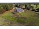 Scenic aerial view of a home with a wraparound porch, surrounded by a vast yard and lush greenery at 6404 Pulley Town Rd, Wake Forest, NC 27587