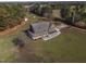Aerial perspective of a home with wraparound porch complemented by outbuildings and lots of green trees at 6404 Pulley Town Rd, Wake Forest, NC 27587