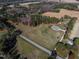 Expansive aerial view of a brick home on a large plot of land surrounded by lush trees and open fields at 6404 Pulley Town Rd, Wake Forest, NC 27587