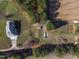 Aerial view showcases a home with outbuildings set amid lush landscaping, woods, and a long private drive at 6404 Pulley Town Rd, Wake Forest, NC 27587