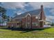 Lush backyard view of a brick home featuring a porch and well-manicured lawn at 6404 Pulley Town Rd, Wake Forest, NC 27587