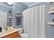 Simple blue bathroom with a standard sink, toilet and shower with a white shower curtain at 6404 Pulley Town Rd, Wake Forest, NC 27587