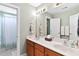 Bright bathroom featuring double sinks, a large mirror, and a separate tub and shower area at 6404 Pulley Town Rd, Wake Forest, NC 27587