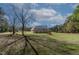 Large brick home with a three-car garage sits on a manicured lawn with mature trees at 6404 Pulley Town Rd, Wake Forest, NC 27587