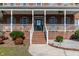 Inviting brick home featuring a classic front porch and manicured landscaping at 6404 Pulley Town Rd, Wake Forest, NC 27587