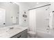 Well-lit bathroom features a shower over tub, speckled granite counters, and soft white accents at 727A Peyton Ave, Durham, NC 27703