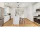 Modern kitchen with stainless steel appliances, white cabinets, and central island with seating at 727A Peyton Ave, Durham, NC 27703