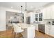 Bright, open kitchen features an island with seating and stainless steel appliances at 727A Peyton Ave, Durham, NC 27703