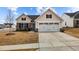 Charming one-story home with a two-car garage and a combination of stone and vertical siding at 82 Coble Farms Pl, Fuquay Varina, NC 27526