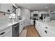 Modern kitchen with white cabinets, stainless steel appliances, and ample counter space for cooking at 82 Coble Farms Pl, Fuquay Varina, NC 27526