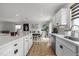 Stylish kitchen with white cabinets, stainless steel appliances, and an open view into the dining area at 82 Coble Farms Pl, Fuquay Varina, NC 27526