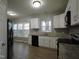 Kitchen features white and black cabinetry, stainless steel appliances, and wood-look flooring at 821 Brookhannah Ct, Fuquay Varina, NC 27526