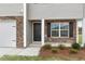 Close up view of the entryway with stone facade and landscaping at 871 Forth Ct, Gibsonville, NC 27249