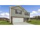 Charming two-story home featuring a stone facade, attached garage, and a spacious lawn at 871 Forth Ct, Gibsonville, NC 27249