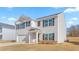 Inviting two-story home with a covered porch, white siding, and black shutters; has an attached garage at 879 Forth Ct, Gibsonville, NC 27249