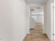 Hallway with wood look floors, white trim and paint, and a view to the living room at 879 Forth Ct, Gibsonville, NC 27249