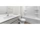 Well-lit bathroom featuring white fixtures, a combined tub and shower, and wood-look flooring at 880 Forth Ct, Gibsonville, NC 27249