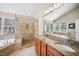 Bathroom with tiled shower, soaking tub, and dual sink vanity with granite counters at 9344 Palm Bay Cir, Raleigh, NC 27617
