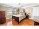 Inviting bedroom with hardwood floors, ceiling fan, and a large window for natural light at 9344 Palm Bay Cir, Raleigh, NC 27617