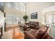 Inviting living room with hardwood floors, large windows, and comfortable leather sofas at 9344 Palm Bay Cir, Raleigh, NC 27617