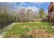 Fenced backyard featuring a cozy fire pit and sandbox area for outdoor enjoyment and activities at 1033 Leatherstone Ln, Fuquay Varina, NC 27526
