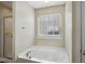 Bathroom featuring a large soaking tub and a glass-enclosed shower at 1033 Leatherstone Ln, Fuquay Varina, NC 27526