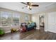 Bedroom with wood-look flooring, two windows, ceiling fan and a connected bathroom at 1033 Leatherstone Ln, Fuquay Varina, NC 27526