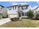 Two-story home with light gray siding, a well-manicured lawn, lush landscaping, and a front-entry garage at 1033 Leatherstone Ln, Fuquay Varina, NC 27526