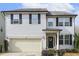 Charming two-story home with a light gray exterior, black shutters, a front-entry garage, and a welcoming front door at 1033 Leatherstone Ln, Fuquay Varina, NC 27526