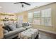 Inviting living room with couch, ottoman, TV, fireplace, and ample natural light from large windows at 1033 Leatherstone Ln, Fuquay Varina, NC 27526