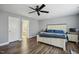 Well-lit main bedroom featuring en suite bathroom, hardwood floors, and large bed at 1033 Leatherstone Ln, Fuquay Varina, NC 27526
