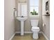 Elegant powder room featuring a pedestal sink, toilet, and natural light from the window at 1035 Zelkova Lane Ln, Chapel Hill, NC 27517