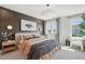 Inviting bedroom with cozy bedding, modern lighting, dark accent wall and a window view to outside at 1035 Zelkova Ln, Chapel Hill, NC 27517