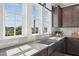 Bright kitchen featuring large windows, stainless steel sink, gray countertops, and shaker style cabinets at 1035 Zelkova Ln, Chapel Hill, NC 27517