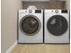 Bright laundry area featuring modern washer and dryer with wooden floors at 1035 Zelkova Lane Ln, Chapel Hill, NC 27517