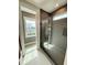 Modern bathroom with glass enclosed shower featuring sleek gray tile and a sunlit window at 1035 Zelkova Ln, Chapel Hill, NC 27517