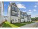 Row of new townhomes featuring gray and white accents, sidewalks and freshly installed lawns at 1035 Zelkova Ln, Chapel Hill, NC 27517