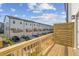 Townhome community featuring a balcony, rear garages, and well manicured lawns at 1035 Zelkova Ln, Chapel Hill, NC 27517
